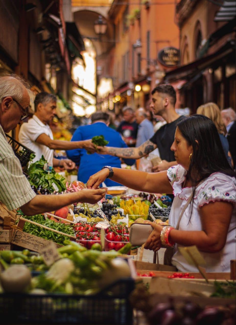 woman wearing white and red blouse buying some veggies